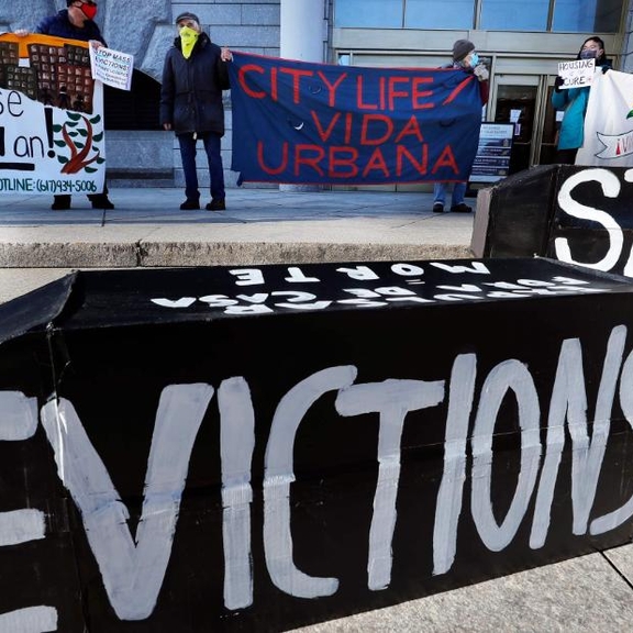 Activists stand with anti-eviction banners.