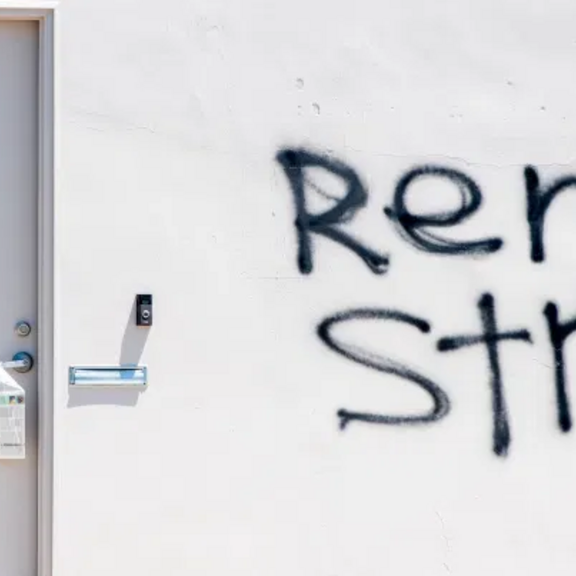 White wall with "rent strike" spray-painted.