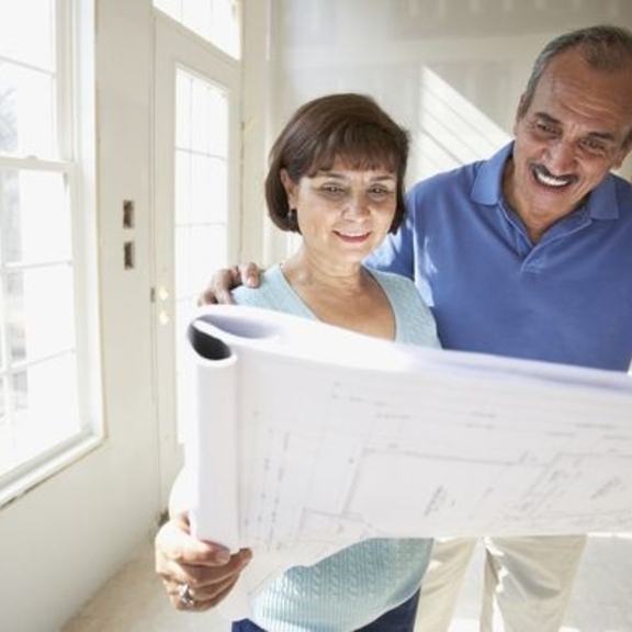Man and woman considering floor plans.