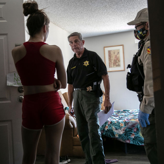 Two eviction enforcement officers standing in woman's home.