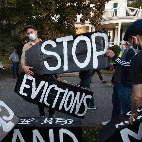Protestors holding "Stop evictions" signs.