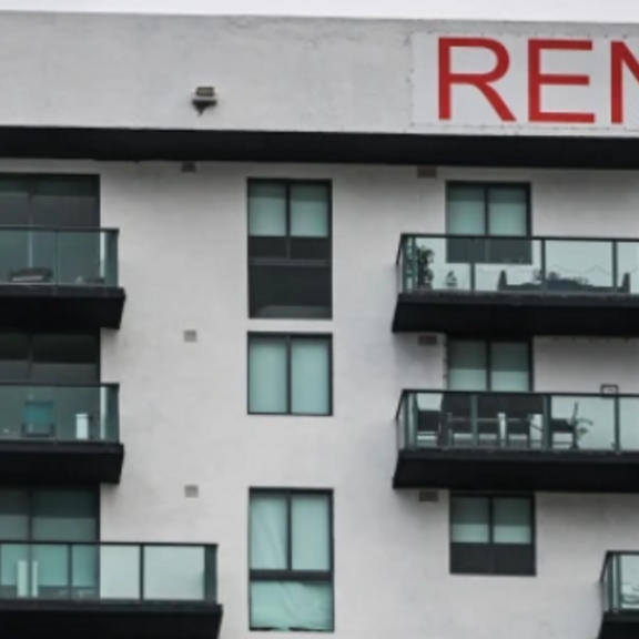 A multifamily building with a RENT sign