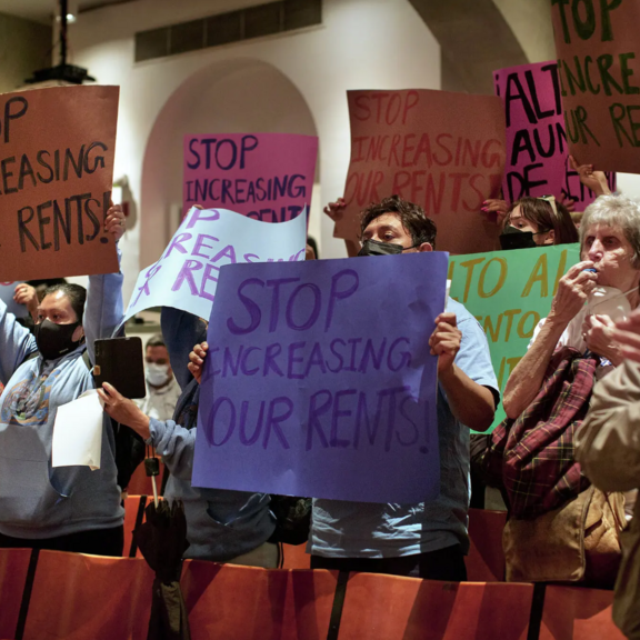 Tenants with signs protesting rent increases.