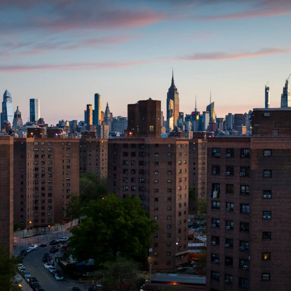 View of multifamily housing and New York City skyline.