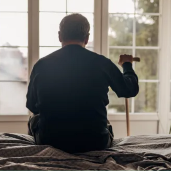 Aging man looking out of window