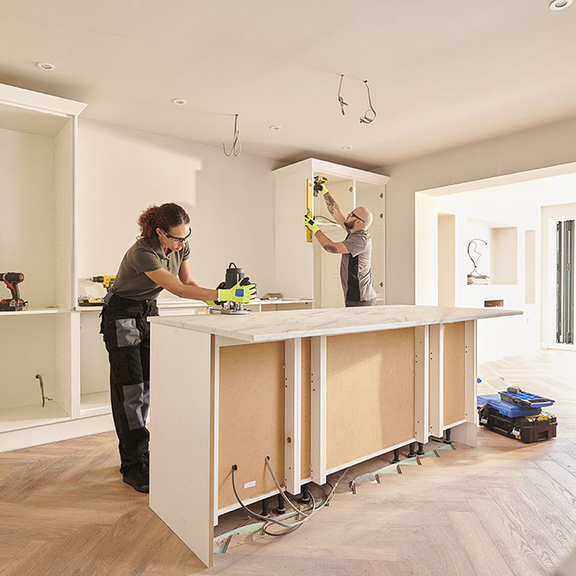 Two contractors working on a kitchen renovation