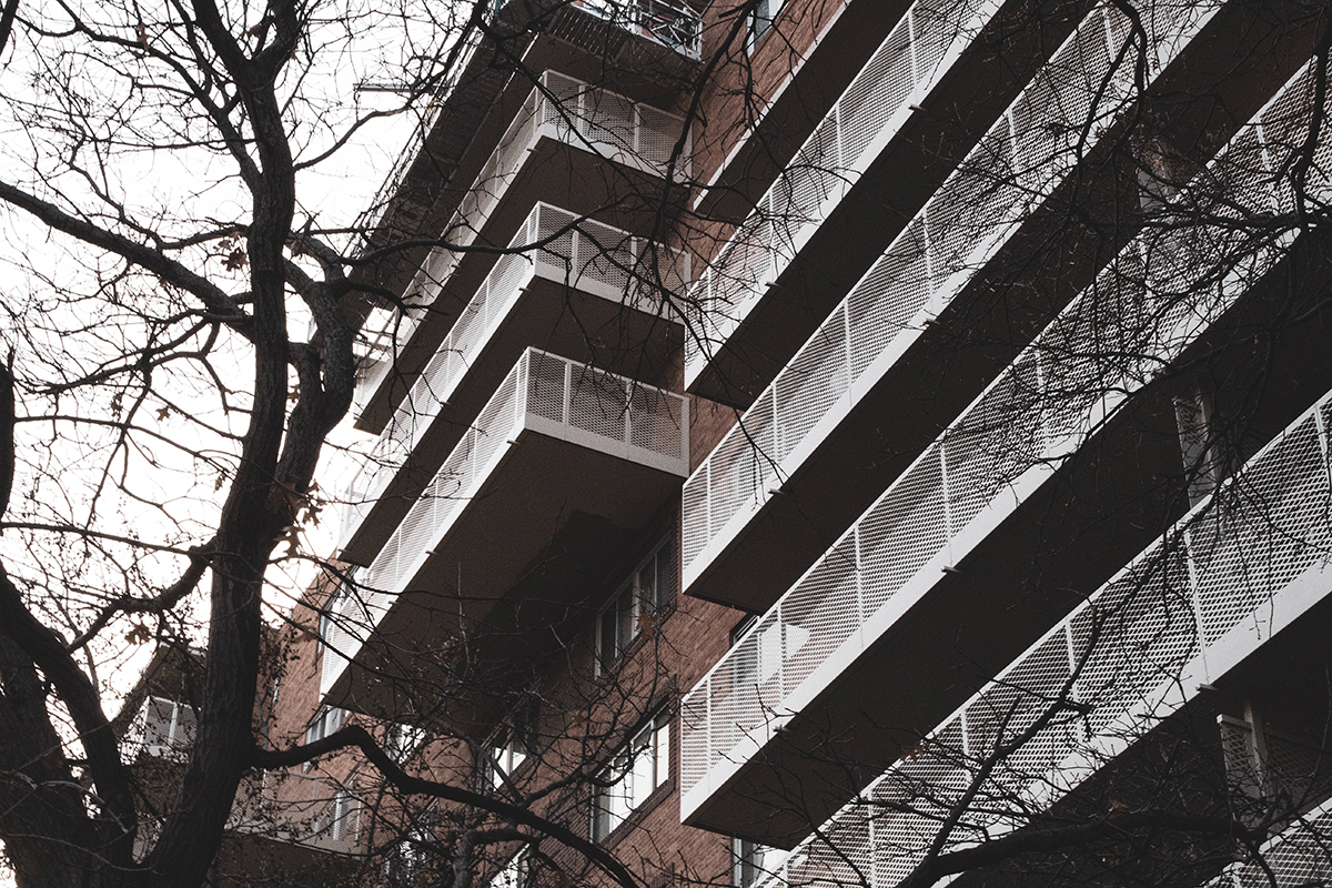 Large brick apartment building with rows of balconies.