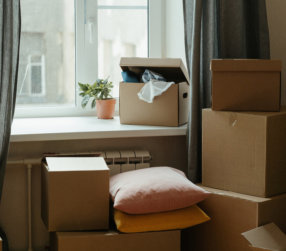 Moving boxes stacked by apartment window.