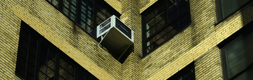 Air conditioners in apartment building windows.