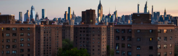 View of multifamily housing and New York City skyline.