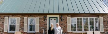 Elderly couple infront of a house